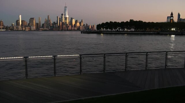 New York City Manhattan Downtown Financial District skyline, World Trade Center tower skyscraper from New Jersey, Hoboken pier, United States. River waterfront urban cityscape, evening dusk twilight.