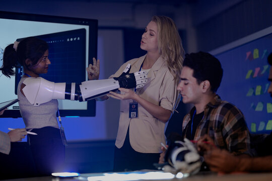 A startup team develops future medical technology. The diverse engineers test a new AI robotic prosthetic, an innovative solution for healthcare and digital transformation.
