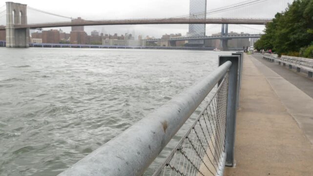 Brooklyn Bridge, Manhattan Bridge from Brooklyn Bridge park, New York City Dumbo, United States. American architecture, famous tourist landmark. Waterfront promenade, riverside esplanade perspective.