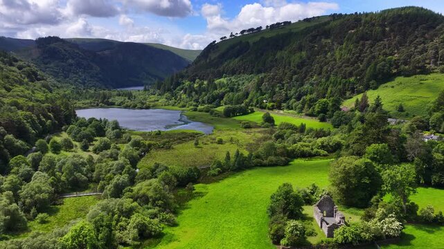 picturesque Glendalough valley in Ireland aerial view, summer hiking and tourism in Ireland, Wicklow mountains with historic medieval village and scenic lake, ruins of ancient tower and church in Glen