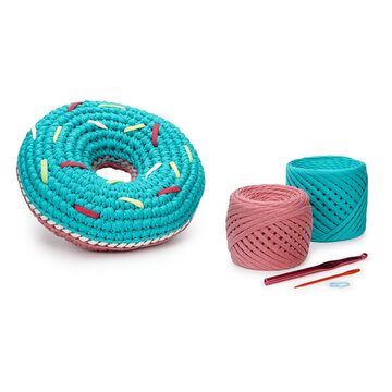 Professional studio product shot of textile ribbon yarn skeins with a round donut plush toy. Perfect presentation template for handicraft workshops and online retail store catalogs.