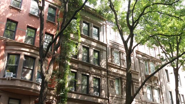 New York City townhouse buildings, brownstone row houses in Manhattan or Brooklyn, United States of America. Classic buildings on residential district street. Real estate property. Rowhouse townhome.
