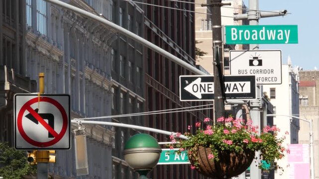 New York City Broadway street sign in Manhattan Midtown, United States. Urban road sign, traffic sign. Building architecture in Flatiron district. Crossroad with 5 fifth avenue. Subway metro globe.