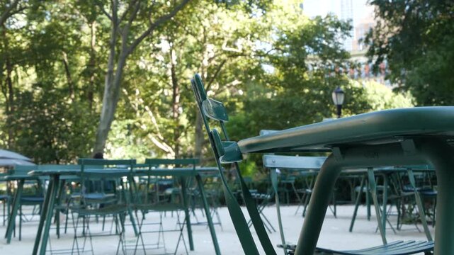 Fifth 5 avenue and Broadway street crossroad, Manhattan Midtown, New York City, United States. Defocused people pedestrians, chairs and tables for picnic in Madison Square Park, Flatiron District .