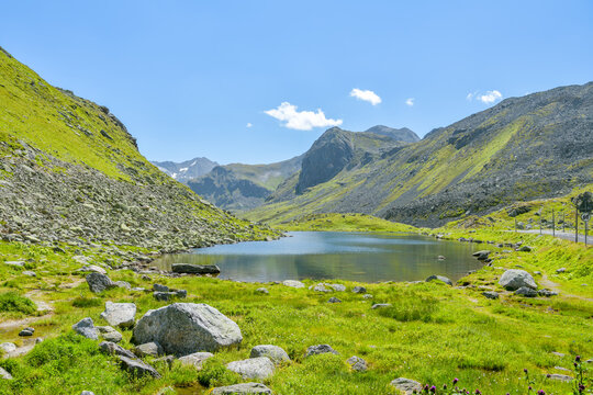 Alpine lake beside a mountain pass road in summer