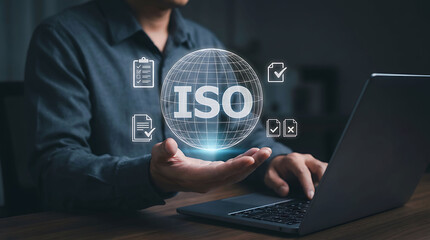 Fototapeta premium Businessman holding virtual global ISO globe icon for quality compliance management standard