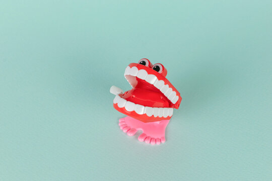 Playful Red Wind-Up Chattering Teeth Toy on a Mint Green Background