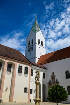 White church tower with clock and blue sky