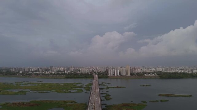 Aerial Drone View of Bridge Crossing River with Dramatic Monsoon Clouds and Expansive Urban Skyline in Surat, Gujarat, India