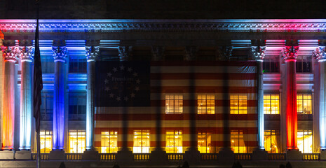 Obraz premium USA patriotic lights on architecture. USA flag decorates federal department. Independence banner honors USA history. Night exterior shows USA celebration.