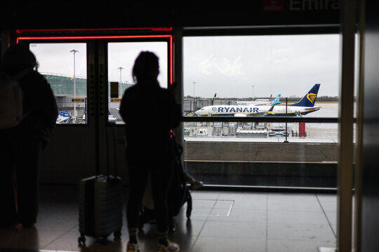 Passengers waiting in airport terminal, watching Ryanair airplane on tarmac, preparing for departure from Stansted Airport, low cost airline travel in January 21, 2026 in London, UK