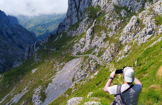 Hiker taking a photo in Picos de Europa National Park Spain
