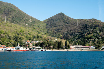 Fototapeta premium Beautiful coastal view of Montenegro with mountains and boats at the harbor.