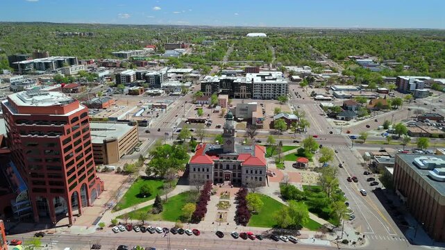 Overhead drone view of historic courthouse with clock tower surrounded by downtown Colorado Springs