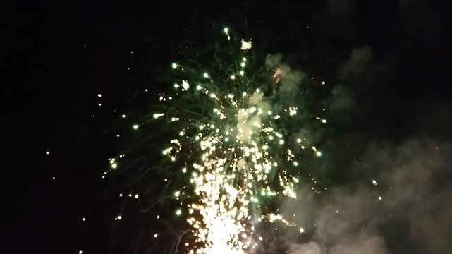 Fireworks explosion, nighttime celebration, green sparks, festive pyrotechnics, holiday display