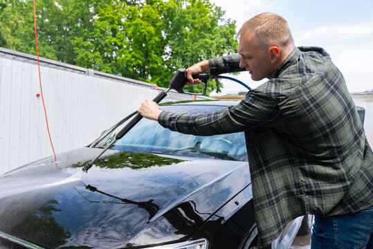 Man washing car at self service car wash with pressure
