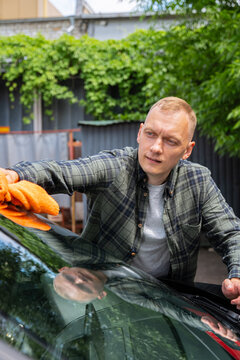 Man washing car at self service car wash with microfiber