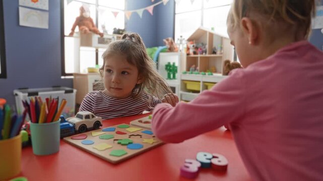 Girl places wooden puzzle pieces on table and reaches to fit colorful shapes in a preschool playroom building; concentration learning.