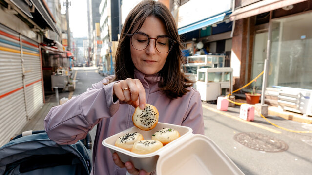 Woman enjoying traditional pan-fried buns at market