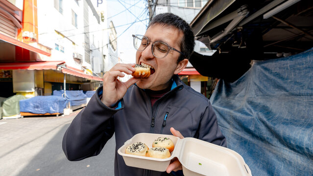 Man enjoying pan-fried buns at Bupyeong Kkangtong Market