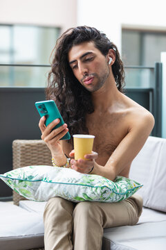 Middle Eastern man with vitiligo using phone with coffee