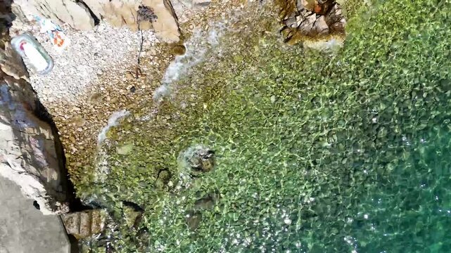 Aerial sea surf. Clear water shore. Turquoise ocean wave. Rocky beach coastline.