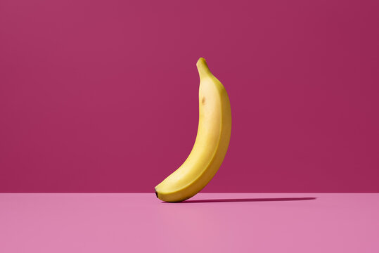 Canary banana on pink background, minimal still life