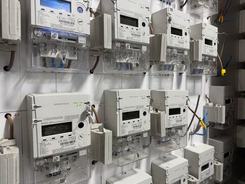 Electricity meters on wall measuring power consumption with cables