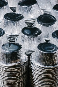 Stack of recycled aluminum foil containers for food storage. Shiny metal dishes prepared for waste sorting and environment protection. Sustainable lifestyle and ecology concept.