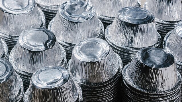 Stacks of aluminum foil containers. Household waste for recycling. Metal packaging for food industry and takeout. Concept of sustainability and responsible disposal of metal trash.