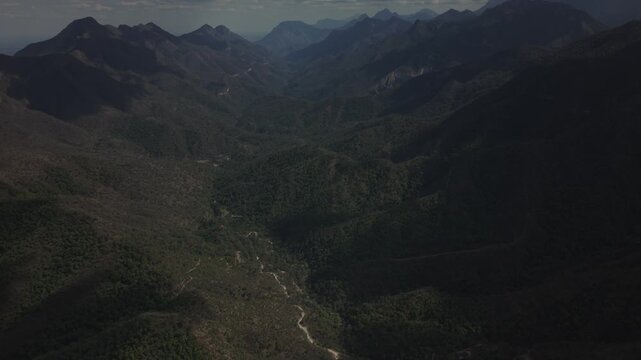 A cinematic aerial drone view overlooking the expansive mountain valleys of El Salto, near Monterrey, Nuevo Le&oacute;n, Mexico. Rolling forested hills, rugged mountain peaks, and dramatic clouds.