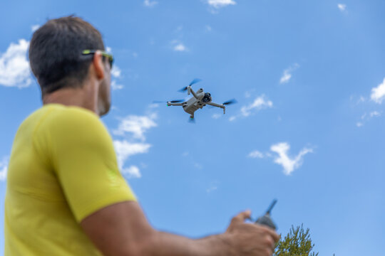 Drone pilot controlling quadcopter in blue summer sky