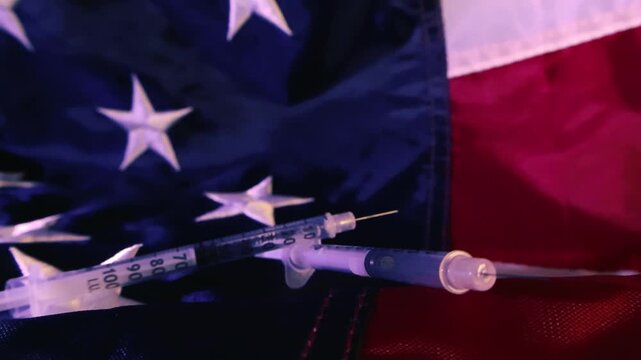 Syringes with needles resting on the stars and stripes of the American flag, a powerful concept representing the opioid epidemic, drug addiction, and healthcare crisis in the United States