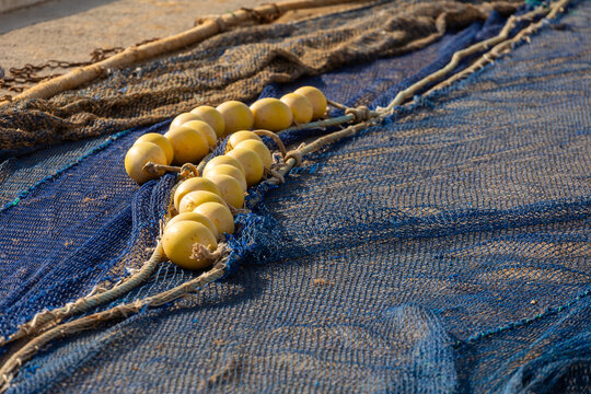 Fishing net with yellow floats drying on a coastal dock