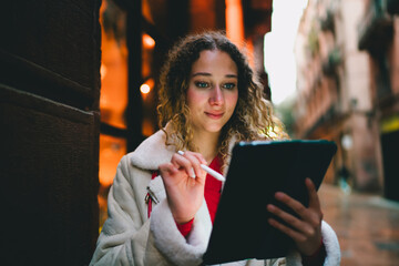 Creative freelancer sketching on digital tablet with stylus in evening city, it professional using mobile device, remote work, online education, modern software development, digital nomad. © BullRun