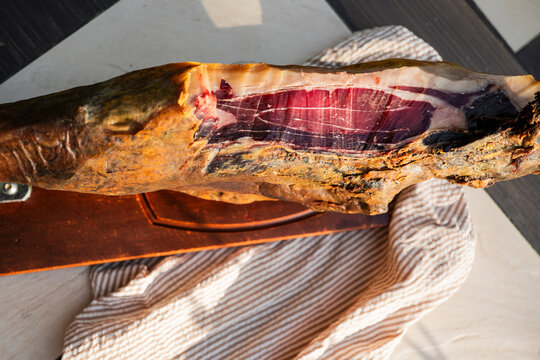 Authentic iberian ham leg displayed on wooden board