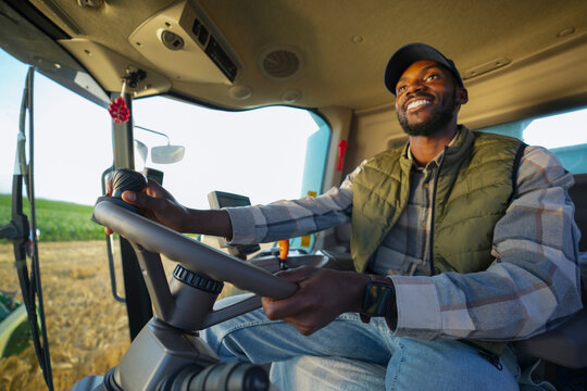 A farmer is seen smiling while driving a tractor across a field. The sun is shining, and crops are growing in the background. The scene shows the joy of farming and hard work.