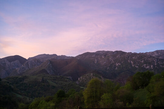 Sunset over Asturias mountain range above green field