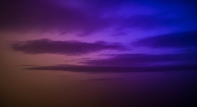 A purple and blue sky with clouds at sunset