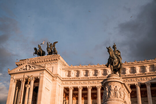 Neoclassical triumphal monument with Corinthian columns and bronze quadriga statues at dusk in Rome