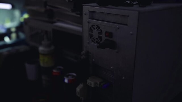 Dusty computer tower on repair bench surrounded by tools and bottles, open ports and worn casing visible, makerspace or repair shop environment, DIY maintenance