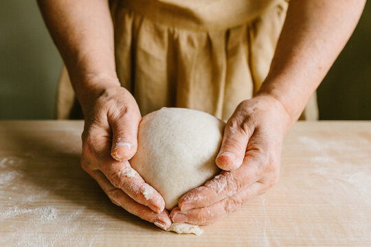 Hands shaping rustic dough for artisan bread fermentation