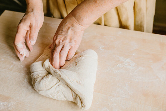 Hands shaping artisan bread dough for rustic fermentation