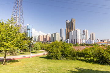 Obraz premium Modern urban skyline and city park green area with skyscrapers in Atasehir district of Istanbul Turkey, natural green background and copy space.