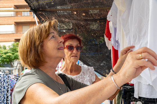 Senior women shopping at outdoor street market in summer
