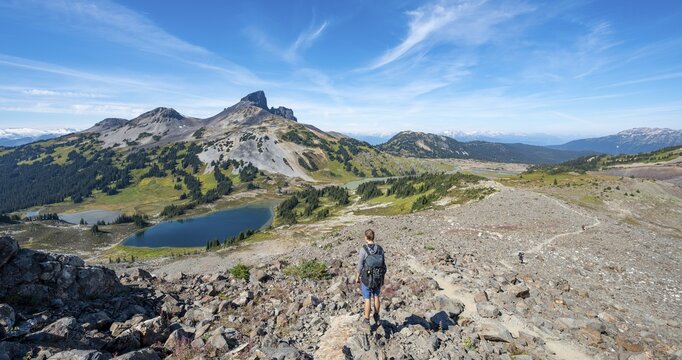 Hikers on trail to Panorama Ridge, Blue Lakes in front of volcanic Black Tusk Mountain, Panorama Ridge, Garibaldi Provincial Park, British Columbia, Canada