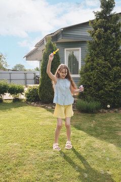Girl playing with bubbles in sunny backyard during summer