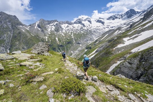 Mountaineer on hiking trail in picturesque mountain landscape, in the background mountain peak Gro&szlig;er L&ouml;ffler and &Ouml;stliche Floitenspitze with glacier Floitenkees, valley Floitengrund, Berliner H&ouml;henweg, Zillertal Alps, Tyrol, Austria