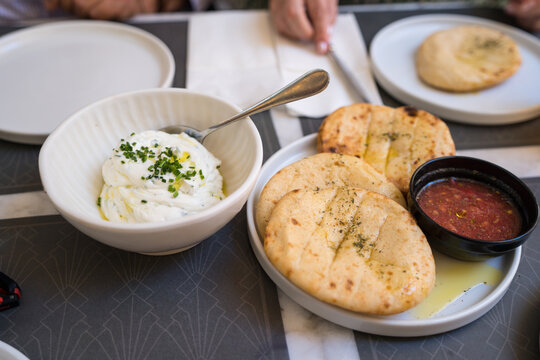 Warm Pita bread with tzatziki and tomato dip on table
