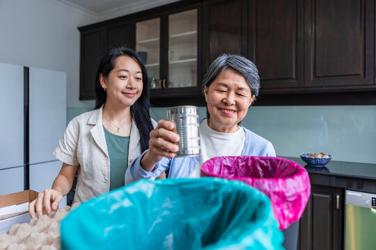 Asian family sorting household waste for recycling at home